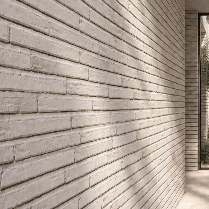 Close-up render of pale textured brickwork in raking light.